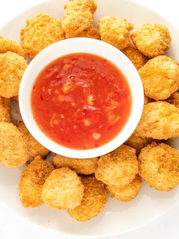 cooked chicken nuggets with dipping sauce at the center.