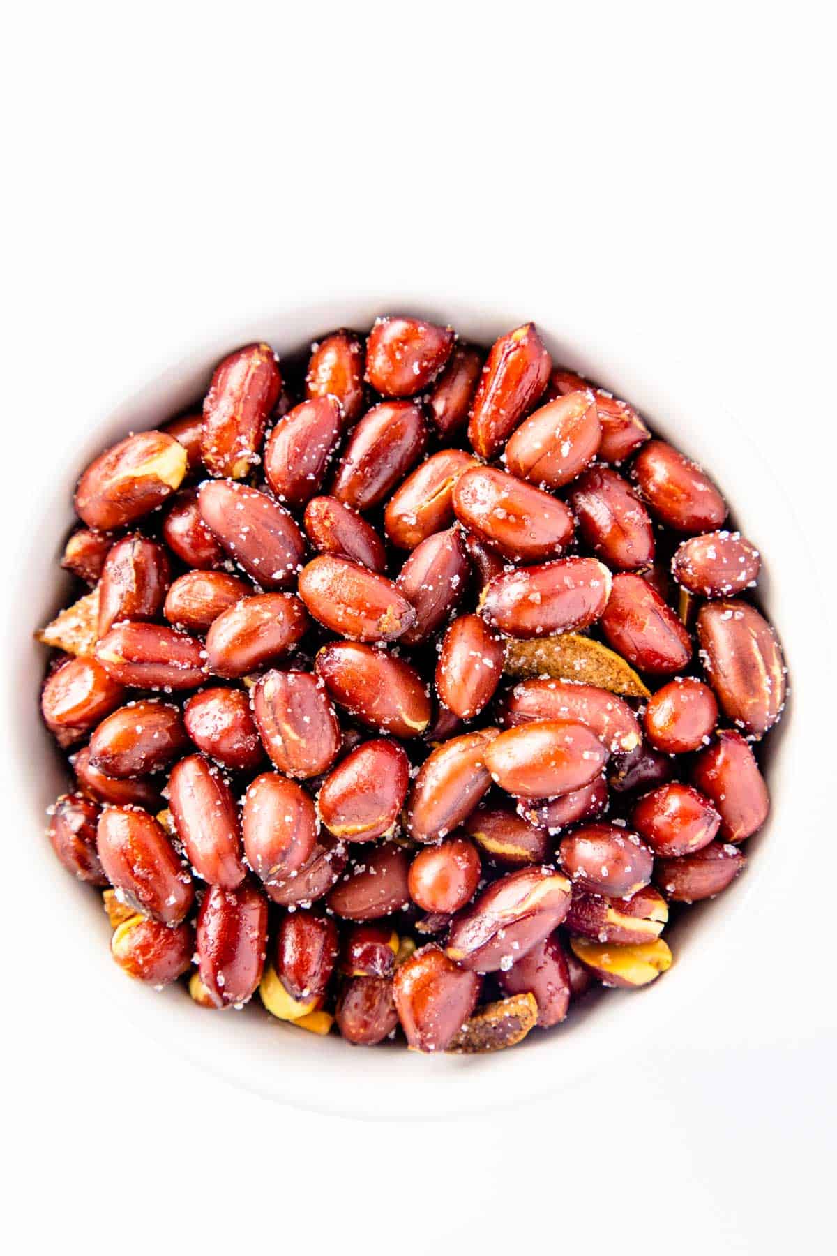 fried garlic peanuts with salt on white bowl.