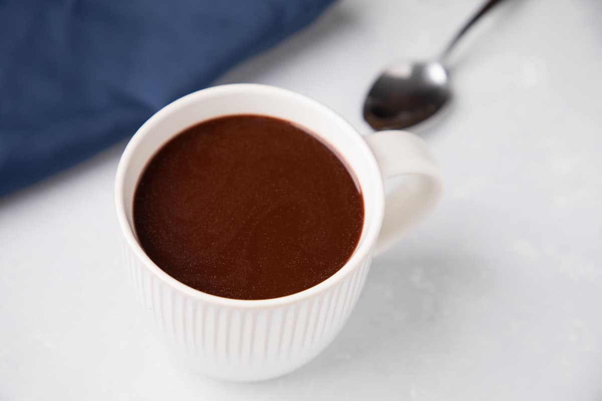 Chocolate drink on the cup with teaspoon.