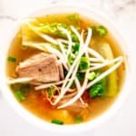 pork sour soup in white bowl with vegetables